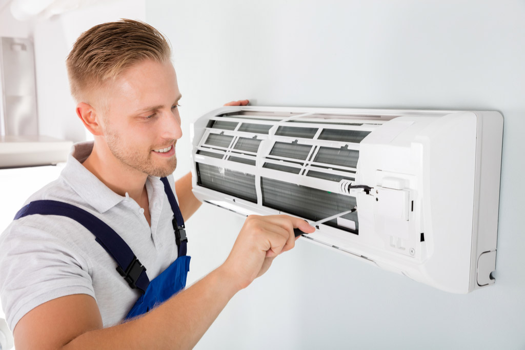 HVAC technician cleaning and repairing a ductless mini split AC in Flagstaff, AZ