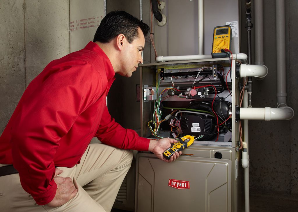 Heating and air conditioning technician servicing an indoor furnace in Flagstaff, AZ