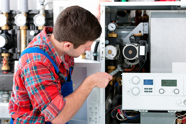 HVAC technician inspecting an indoor heating system in Flagstaff, AZ