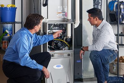 65df8c11f3e4c468cbd351a5_furnace repair vs replacement – Copy HVAC technician explaining furnace repair and maintenance to a homeowner in Flagstaff, AZ