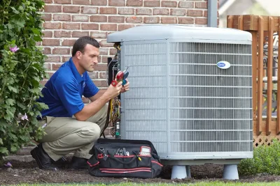 design-air-heating-and-air-conditioning-decatur-il-05 – Copy HVAC technician inspecting an outdoor air conditioning unit in Flagstaff, AZ
