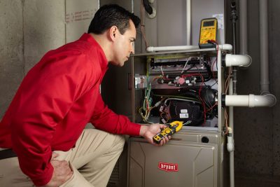 furnace repair Heating and air conditioning technician servicing an indoor furnace in Flagstaff, AZ